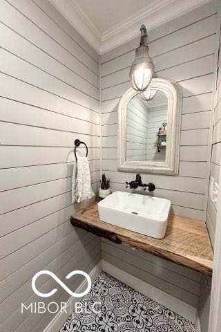 410 Hawthorn Ct, Seymour, IN 47274 - bathroom featuring crown molding, wooden walls, and tile patterned flooring