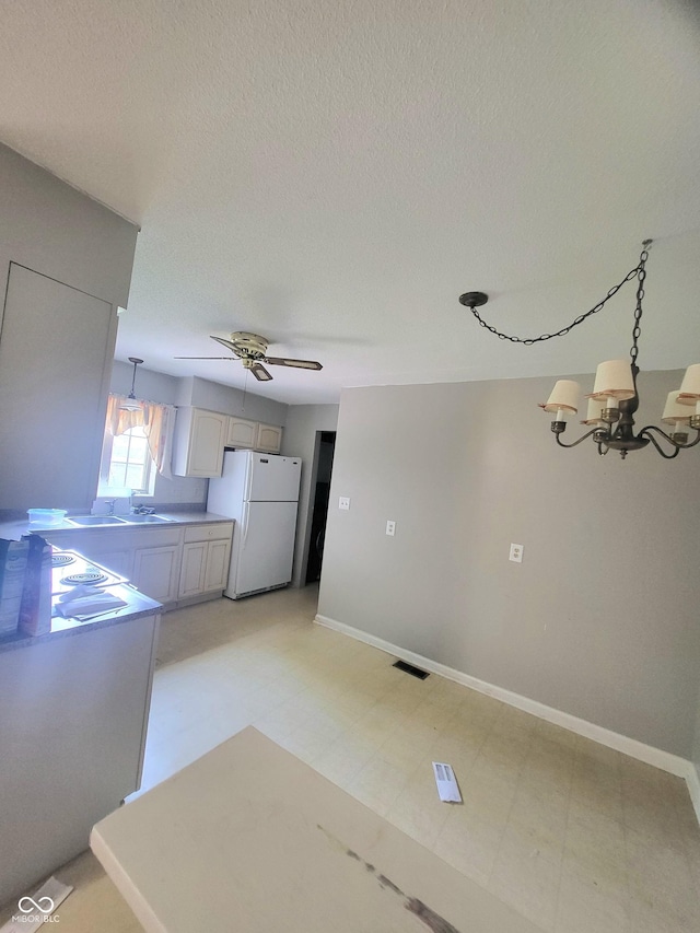 7576 S Carlisle St, Terre Haute, IN 47802 - kitchen with freestanding refrigerator, a chandelier, ceiling fan, pendant lighting, and a textured ceiling