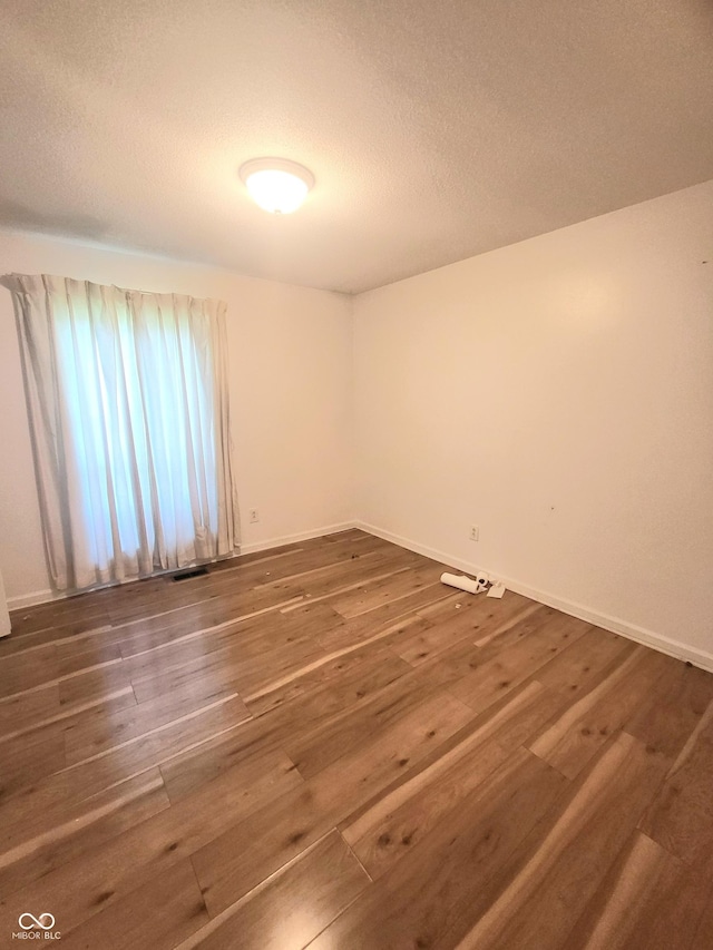 7576 S Carlisle St, Terre Haute, IN 47802 - spare room featuring wood finished floors and a textured ceiling