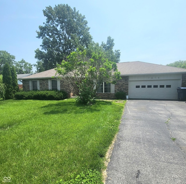 7576 S Carlisle St, Terre Haute, IN 47802 - view of front of property featuring brick siding, driveway, a front lawn, and an attached garage