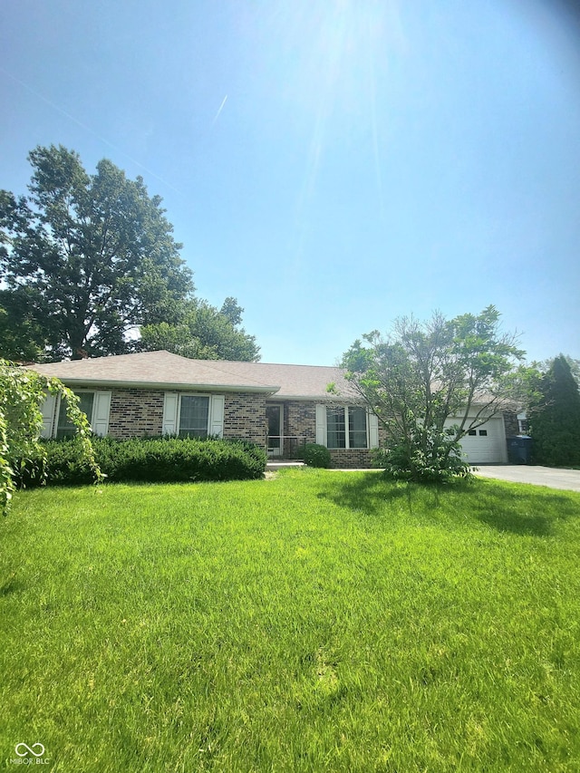 7576 S Carlisle St, Terre Haute, IN 47802 - single story home with stone siding, a front lawn, concrete driveway, and a garage