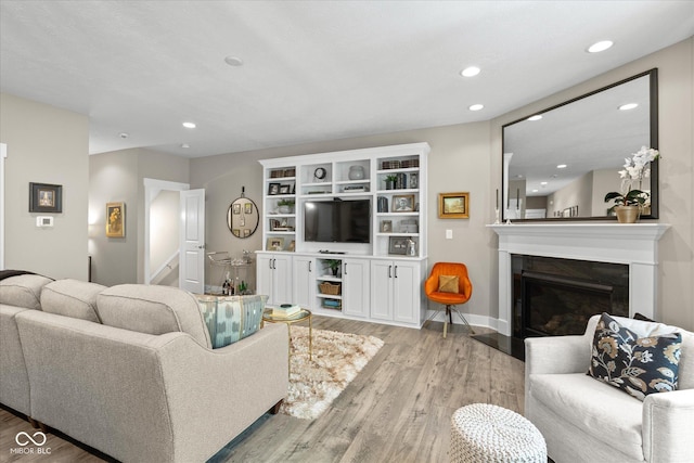 14442 Treasure Creek Ln, Fishers, IN 46038 - living area with light wood-style floors, a glass covered fireplace, and recessed lighting