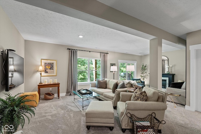 14442 Treasure Creek Ln, Fishers, IN 46038 - living room with carpet flooring, a textured ceiling, and a glass covered fireplace