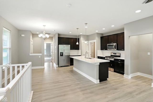 14474 Treasure Creek Ln, Fishers, IN 46038 - kitchen featuring appliances with stainless steel finishes, light wood-style flooring, recessed lighting, light countertops, and a chandelier