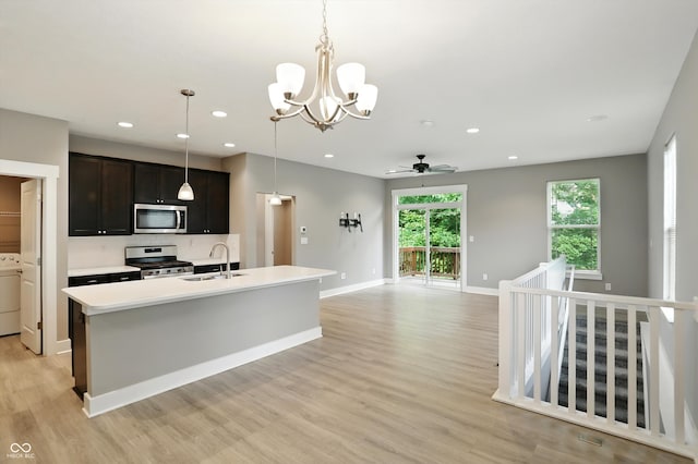 14474 Treasure Creek Ln, Fishers, IN 46038 - kitchen with stainless steel appliances, a chandelier, light wood finished floors, washer / dryer, and light countertops