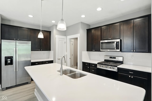14474 Treasure Creek Ln, Fishers, IN 46038 - kitchen with stainless steel appliances, tasteful backsplash, a kitchen island with sink, pendant lighting, and light wood-style flooring