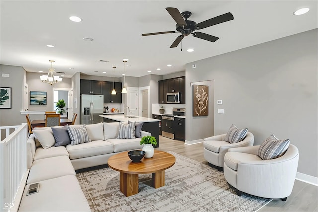 14474 Treasure Creek Ln, Fishers, IN 46038 - living area with light wood-style flooring, recessed lighting, a ceiling fan, and a chandelier