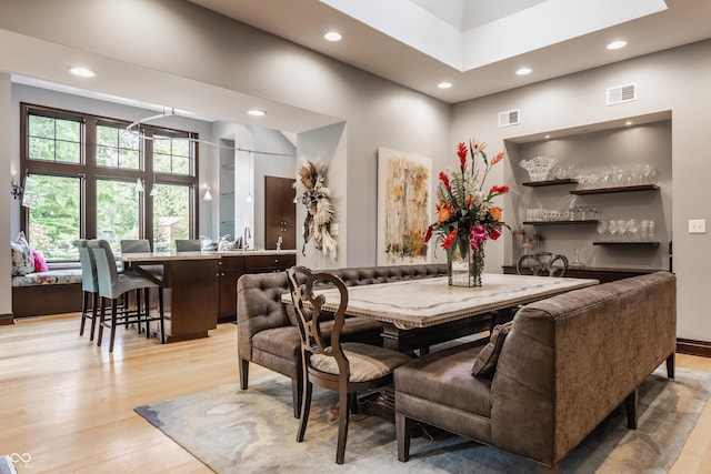 8651 Emerald Ln, Indianapolis, IN 46260 - dining space with light wood-type flooring, recessed lighting, wet bar, and a high ceiling