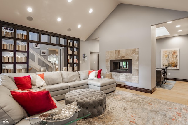 8651 Emerald Ln, Indianapolis, IN 46260 - living room with high vaulted ceiling, wood finished floors, a fireplace, a chandelier, and recessed lighting