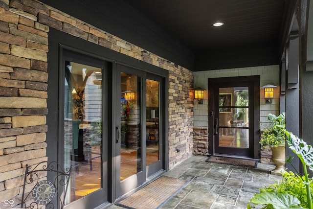 8651 Emerald Ln, Indianapolis, IN 46260 - view of exterior entry featuring stone siding and a porch