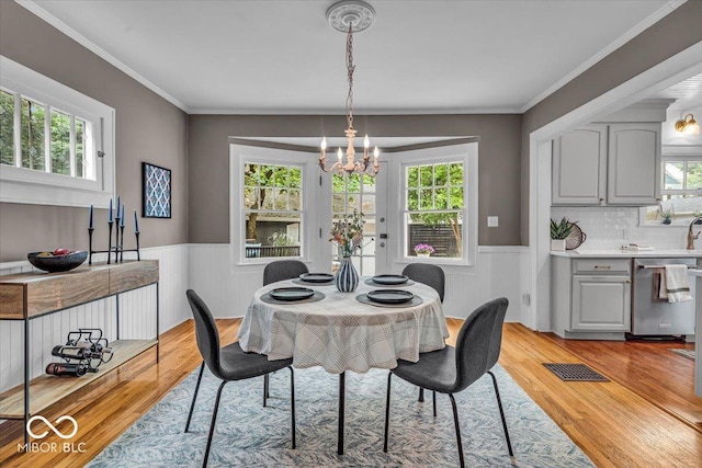 4732 N Kenwood Ave, Indianapolis, IN 46208 - dining area featuring a chandelier, wainscoting, plenty of natural light, light wood finished floors, and crown molding