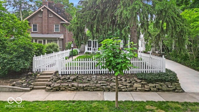 4732 N Kenwood Ave, Indianapolis, IN 46208 - view of front facade with a fenced front yard, a chimney, and brick siding