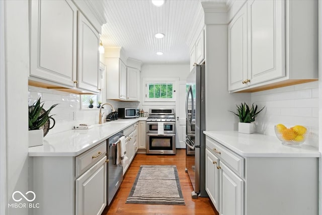 4732 N Kenwood Ave, Indianapolis, IN 46208 - kitchen with stainless steel appliances, wood finished floors, backsplash, white cabinetry, and recessed lighting