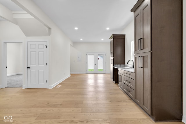 2031 Central Ave, Indianapolis, IN 46202 - kitchen with light countertops, light wood finished floors, dark brown cabinets, recessed lighting, and french doors