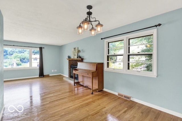 3630 E Morningside Dr, Bloomington, IN 47408 - dining space featuring light wood-type flooring, a chandelier, and a fireplace