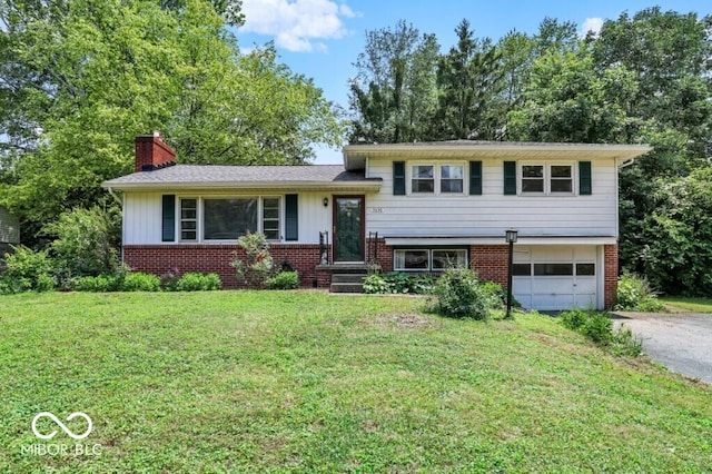 3630 E Morningside Dr, Bloomington, IN 47408 - tri-level home featuring asphalt driveway, a chimney, brick siding, an attached garage, and a front yard