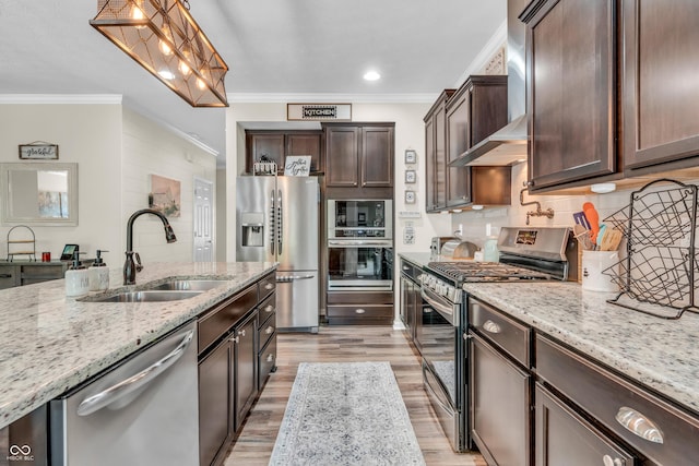 9231 E Poynter Dr, Morgantown, IN 46160 - kitchen with appliances with stainless steel finishes, crown molding, wall chimney exhaust hood, dark brown cabinets, and light wood-style floors