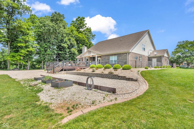 9231 E Poynter Dr, Morgantown, IN 46160 - back of property with a deck, brick siding, a vegetable garden, and a chimney