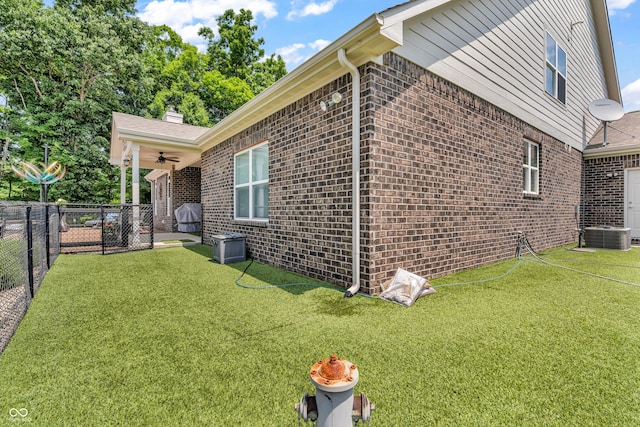 9231 E Poynter Dr, Morgantown, IN 46160 - view of side of home featuring a fenced backyard, brick siding, ceiling fan, and a chimney