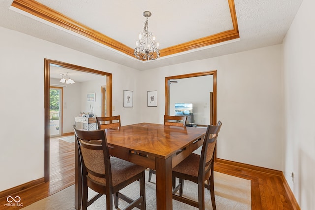 6629 Woodcrest Dr, Avon, IN 46123 - dining room featuring a chandelier, a raised ceiling, and light wood-type flooring