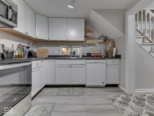 1532 E Markwood Ave, Indianapolis, IN 46227 - kitchen featuring appliances with stainless steel finishes, light wood-style flooring, white cabinetry, and dark stone countertops