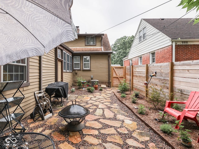 1532 E Markwood Ave, Indianapolis, IN 46227 - fenced backyard featuring an outdoor fire pit, a patio area, area for grilling, and a gate