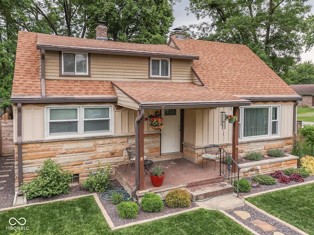 1532 E Markwood Ave, Indianapolis, IN 46227 - view of front facade featuring a chimney, stone siding, board and batten siding, a shingled roof, and a patio