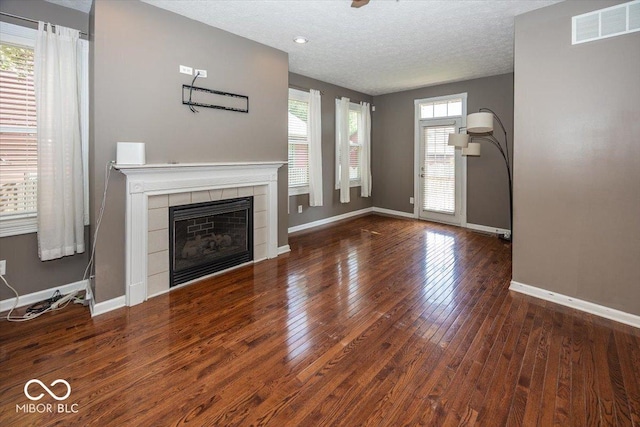 2325 N Talbott St, Indianapolis, IN 46205 - unfurnished living room featuring hardwood / wood-style flooring, a fireplace, and a textured ceiling