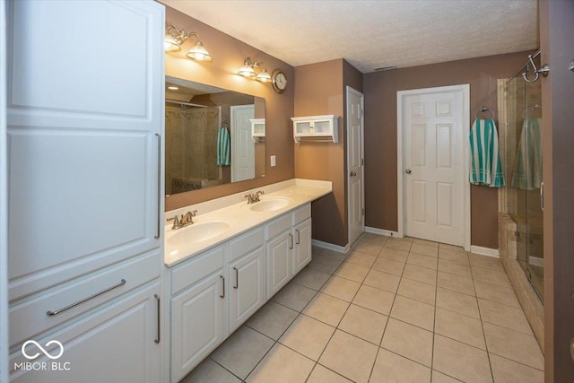 2325 N Talbott St, Indianapolis, IN 46205 - full bath with tile patterned flooring, double vanity, tiled shower, and a textured ceiling