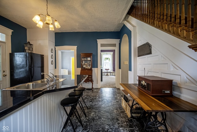 426 N Franklin St, Greensburg, IN 47240 - kitchen featuring freestanding refrigerator, dark countertops, a chandelier, a textured ceiling, and pendant lighting