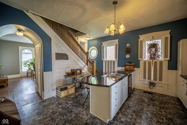 426 N Franklin St, Greensburg, IN 47240 - kitchen with a wainscoted wall, a textured ceiling, white cabinets, a chandelier, and dark countertops