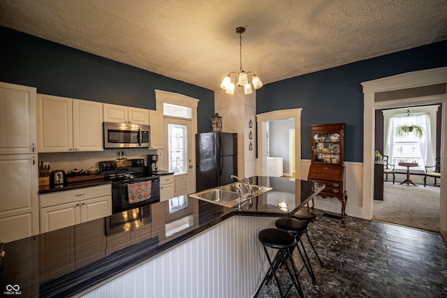 426 N Franklin St, Greensburg, IN 47240 - kitchen with black appliances, dark countertops, white cabinetry, a textured ceiling, and a chandelier