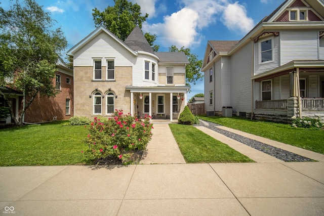 426 N Franklin St, Greensburg, IN 47240 - victorian home featuring covered porch, a front lawn, and brick siding