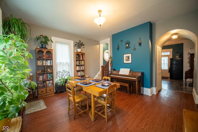 426 N Franklin St, Greensburg, IN 47240 - dining room featuring arched walkways, dark wood-style flooring, and stairs