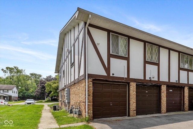 10016 Penrith Dr, Indianapolis, IN 46229 - view of property exterior featuring an attached garage, stucco siding, and stone siding