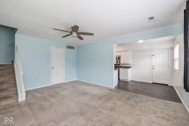 10016 Penrith Dr, Indianapolis, IN 46229 - unfurnished living room featuring dark colored carpet, ceiling fan, and stairs