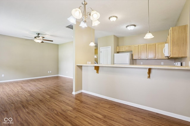 1138 Topp Creek Dr, Indianapolis, IN 46214 - kitchen featuring white appliances, dark wood finished floors, a breakfast bar, and light brown cabinets
