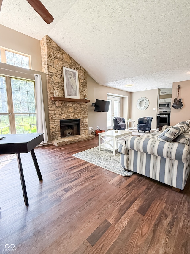 7470 Charrington Ct, Indianapolis, IN 46254 - living area featuring a textured ceiling, dark wood-style floors, healthy amount of natural light, ceiling fan, and a stone fireplace