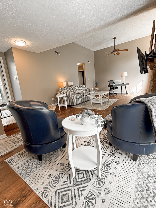 7470 Charrington Ct, Indianapolis, IN 46254 - living room with wood finished floors, ceiling fan, lofted ceiling, and a textured ceiling