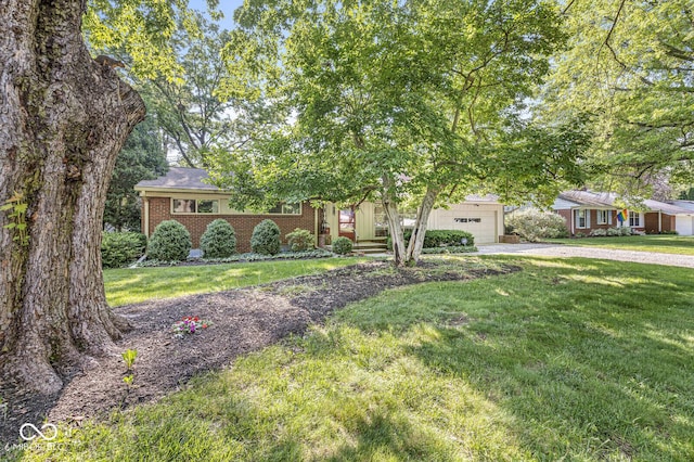 5841 N Parker Ave, Indianapolis, IN 46220 - view of front of house with driveway, brick siding, an attached garage, and a front lawn