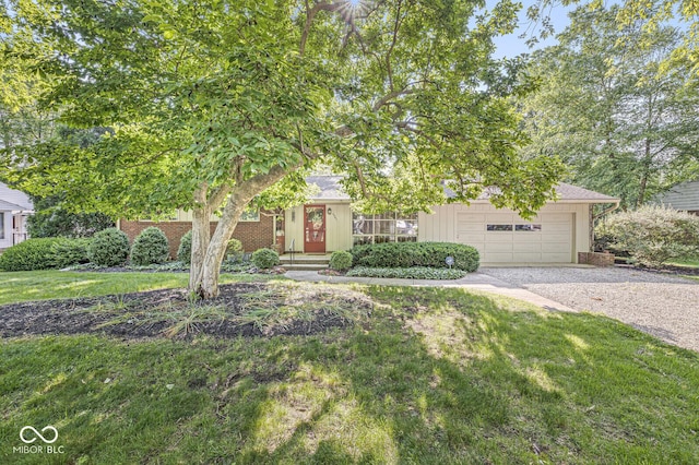 5841 N Parker Ave, Indianapolis, IN 46220 - obstructed view of property with gravel driveway, an attached garage, a front yard, and brick siding