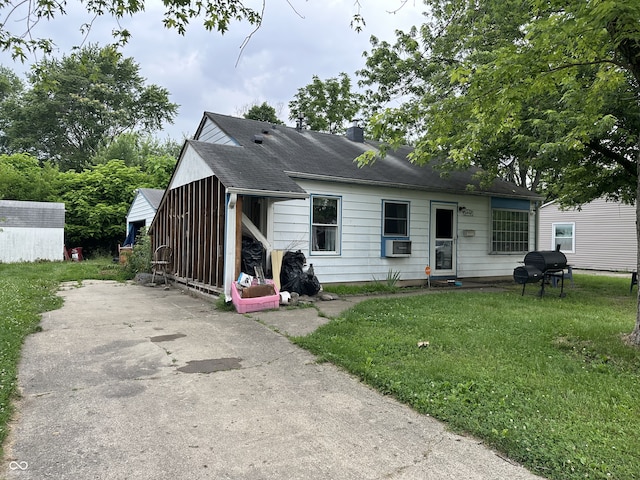 3440 Brewer Dr, Indianapolis, IN 46222 - view of front of home with a front lawn, a chimney, cooling unit, and a storage shed