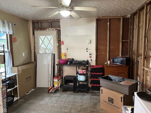 3440 Brewer Dr, Indianapolis, IN 46222 - kitchen with black microwave, ceiling fan, unfinished concrete floors, a textured ceiling, and freestanding refrigerator