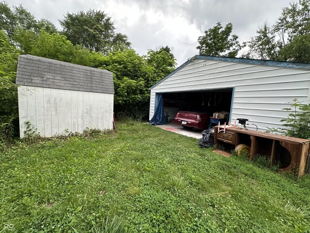 3440 Brewer Dr, Indianapolis, IN 46222 - view of green lawn featuring an outdoor structure and a detached garage