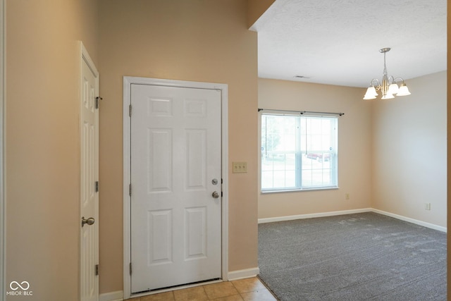 7715 Bolero Dr, Camby, IN 46113 - foyer with a chandelier, light tile patterned floors, and light colored carpet