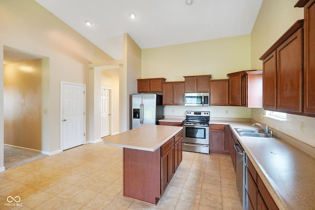 7715 Bolero Dr, Camby, IN 46113 - kitchen featuring appliances with stainless steel finishes, a kitchen island, high vaulted ceiling, light countertops, and brown cabinets