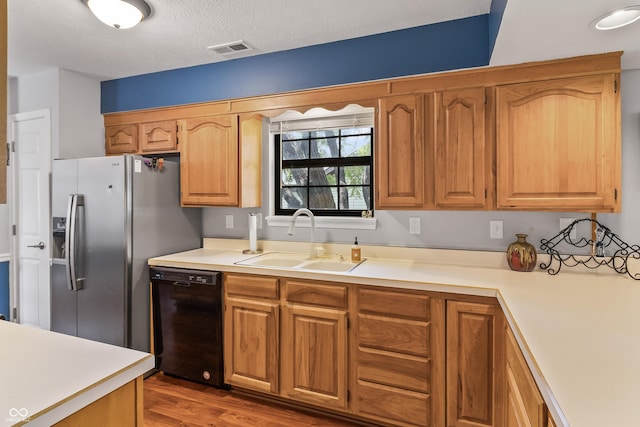 7616 Derrek Pl, Indianapolis, IN 46219 - kitchen with black dishwasher, light countertops, wood finished floors, stainless steel fridge with ice dispenser, and a textured ceiling