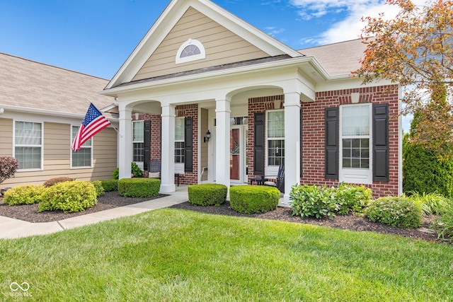 13327 Hockley Dr, Fishers, IN 46037 - view of front of house with brick siding, a porch, a front lawn, and a shingled roof