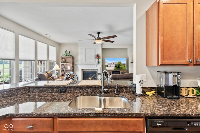 13327 Hockley Dr, Fishers, IN 46037 - kitchen with dishwashing machine, open floor plan, brown cabinets, a ceiling fan, and a fireplace