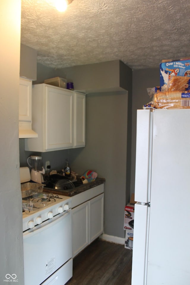 1703 E 34th St, Indianapolis, IN 46218 - kitchen with white appliances, premium range hood, dark wood-style flooring, white cabinetry, and a textured ceiling